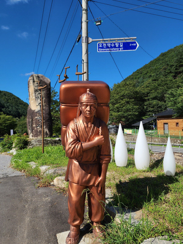 오전약수탕길에 세워진 보부상 조형물.